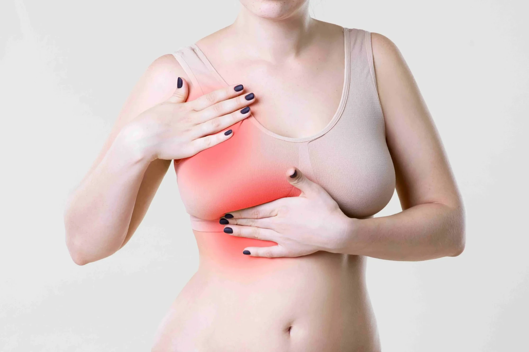 Woman touching her breast and chest wall, with the painful area highlighted in red